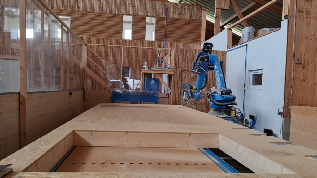 This robot is cutting out openings in a wall panel designed for a modular home.