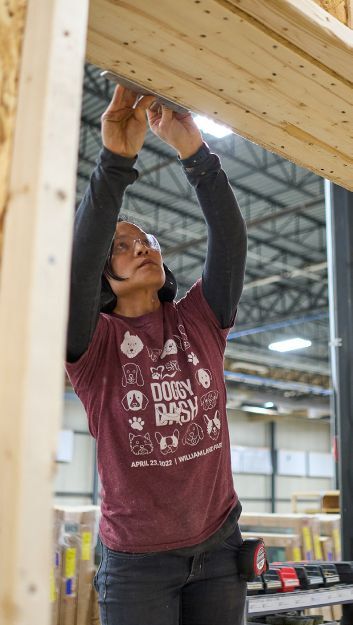Apprentice Hong Duong works in Bensonwood’s Keene, N.H. facility where windows and doors are installed into walls built for quality and energy efficiency
and then shipped to site for fast installation. Photo by Zach Davidson for
Bensonwood