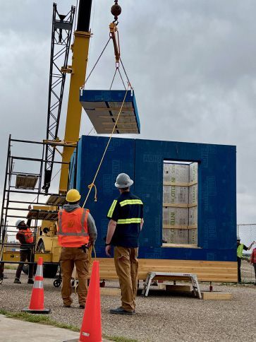 Students maneuver the roof panel for placement during installer training.
Courtesy B.Public Prefab