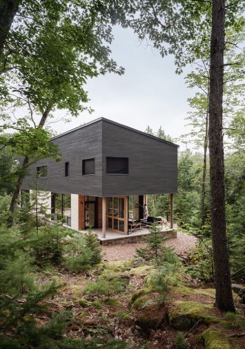 A limited buildable footprint inspired designers at OPAL to create a two-story porch at one end of the building. The overlapping spaces created by this porch include a sheltered entry, a screen porch and an upstairs sleeping porch. Photo by Trent Bell Photography