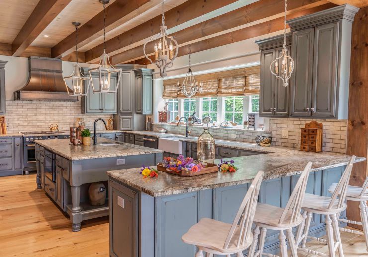 The kitchen was designed with plenty of space for the family to gather. The peninsula provides ample seating for the family along with guests who can visit with the owner during a party. Timber beams in the ceiling tie the kitchen into the overall theme of the home. Photo credit: Brett Hosterman