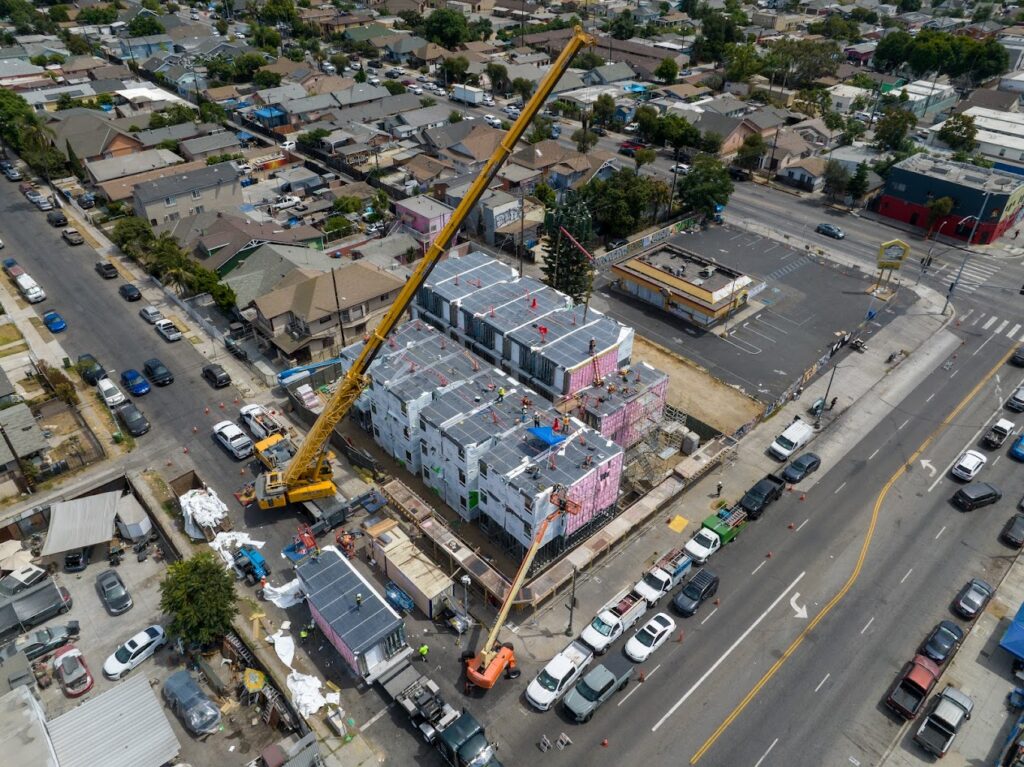 The building consists of 70 modules, each on a 420 sq. ft. standardized chassis. Ground broke in June 2025, and the building was set in 10 working days. After stacking, SoLa takes care of unit-to-unit utility connections, dry-in, roofing, exterior cladding, finishes and landscaping. Residents are expected to start moving in during May or June 2026.