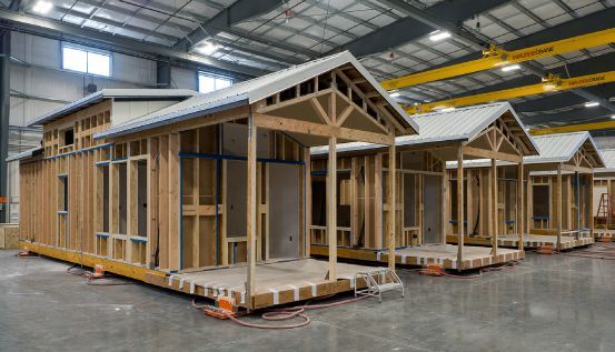 Multiple homes under construction simultaneously on the floor of Fading West’s 110,000 sq. ft. climate-controlled factory in Buena Vista, Colorado — where 25+ homes are produced every month. Photo credit: Fading West