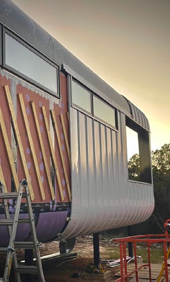 The Villa has white steel cladding installed over 3/4” battens, allowing an air space between sheathing and cladding.  photo courtesy of G-pod