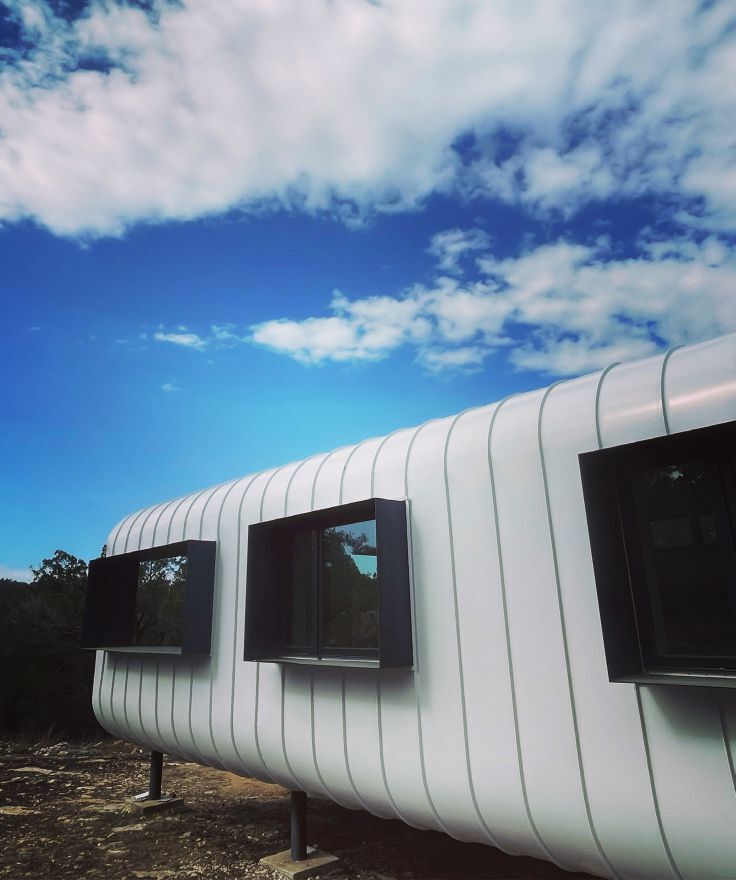 Finished futuristic-looking cladding and triple-pane windows. The fabricated 1/4” aluminum exterior window hoods provide shade without traditional roof overhangs.  photo courtesy of G-pod